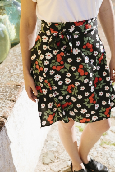 Falda mini cruzada negra con flores rojas y blancas